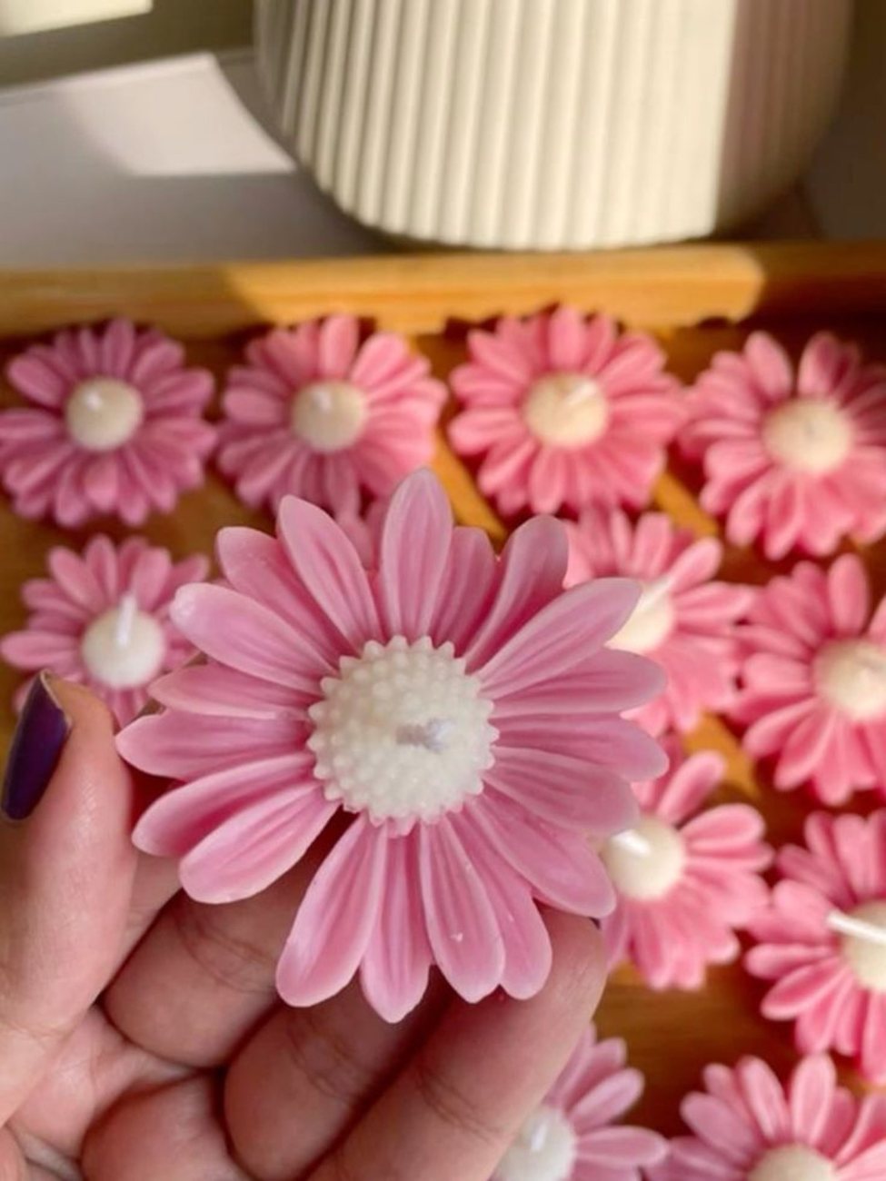 Pink daisy-shaped handmade candle